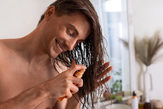 Man applying hair product in bathroom